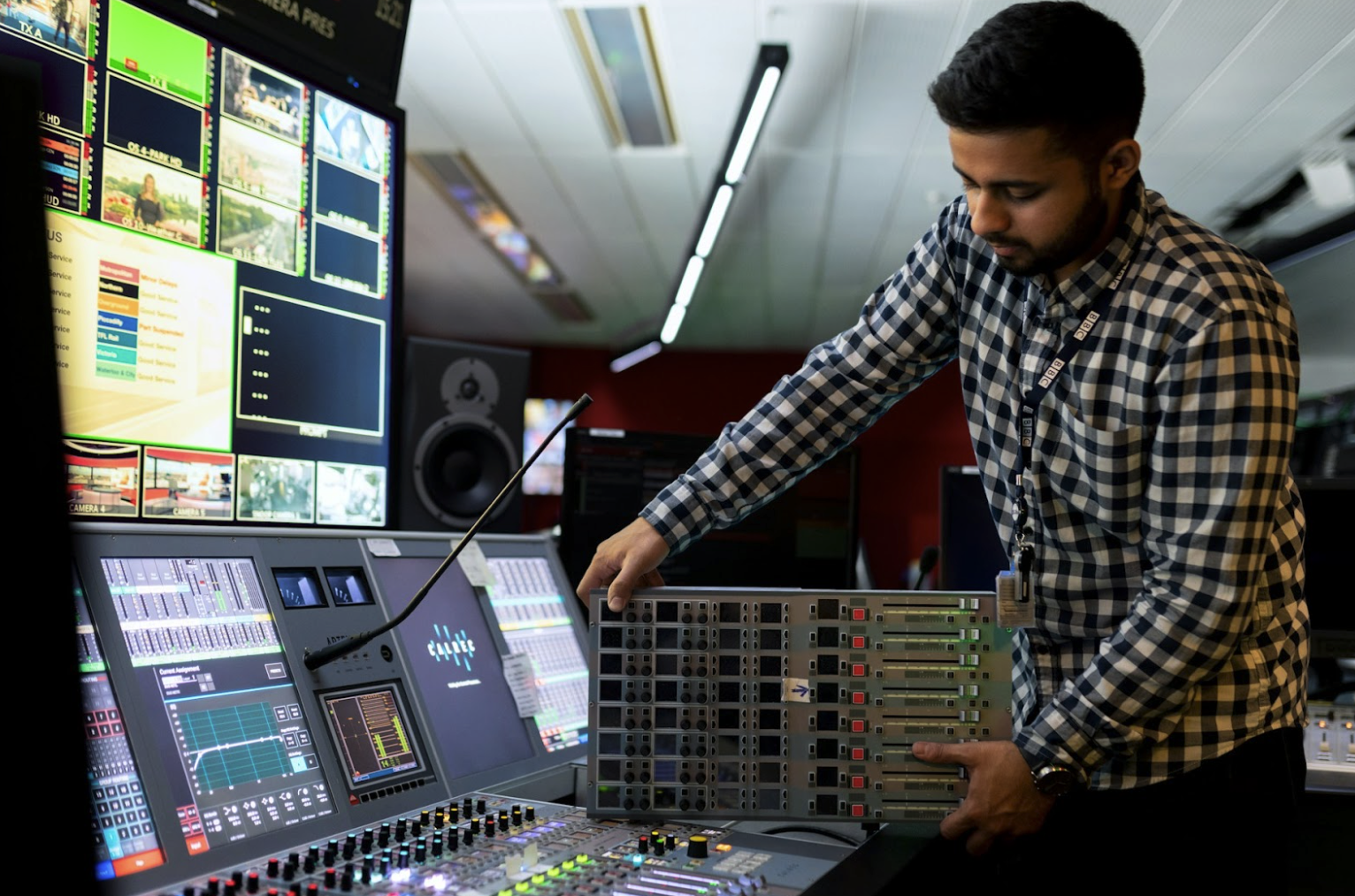 Broadcast audio control room with professional mixing console and audio processing equipment.
