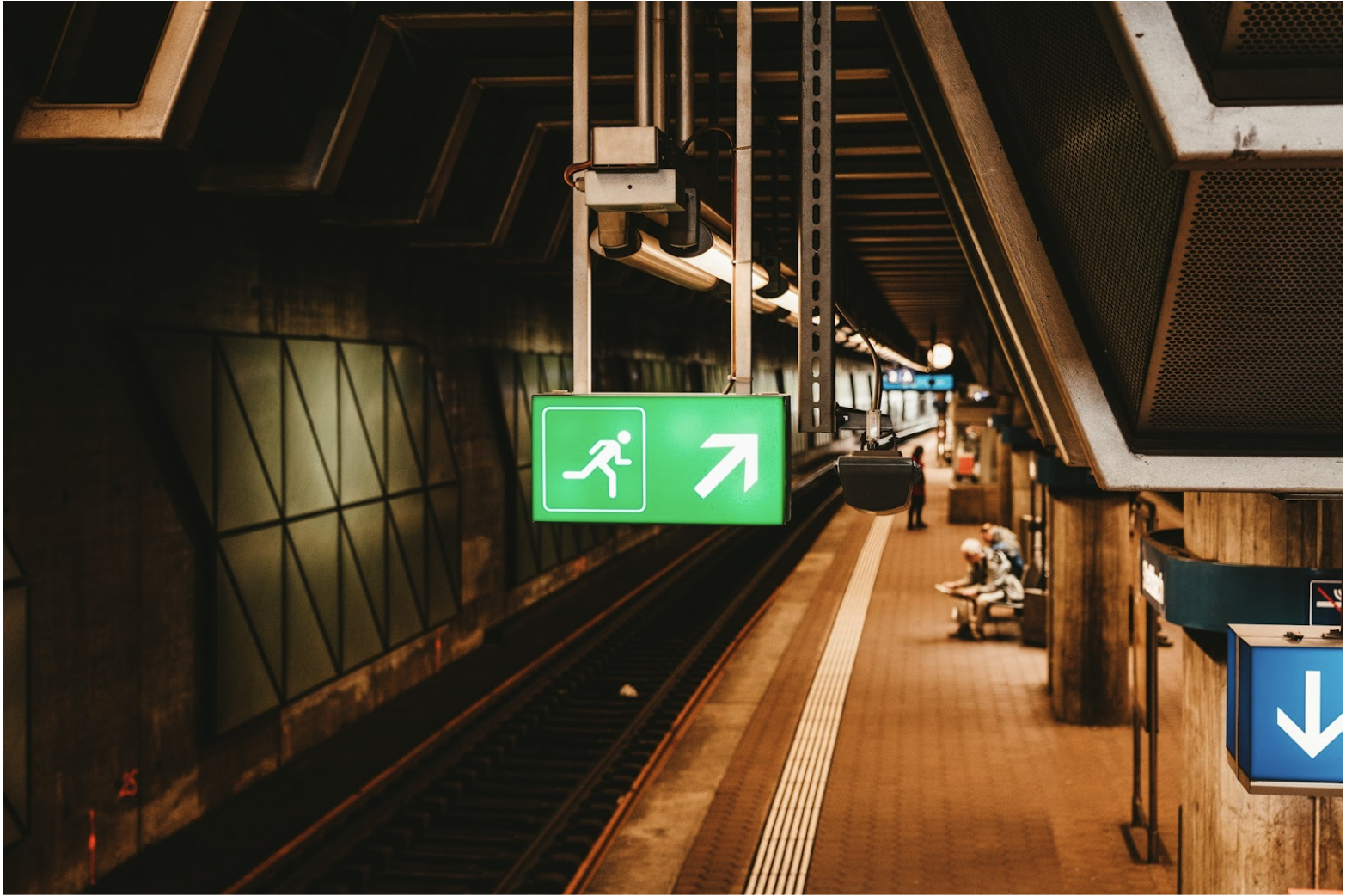 Emergency exit sign in a commercial transit station, representing life-safety systems supported by fire alarm cable and reliable low-voltage system performance