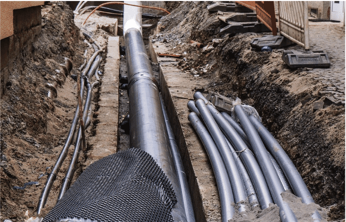 A trench showcasing durable, waterproof, professional-grade direct burial cables alongside a utility pipe
