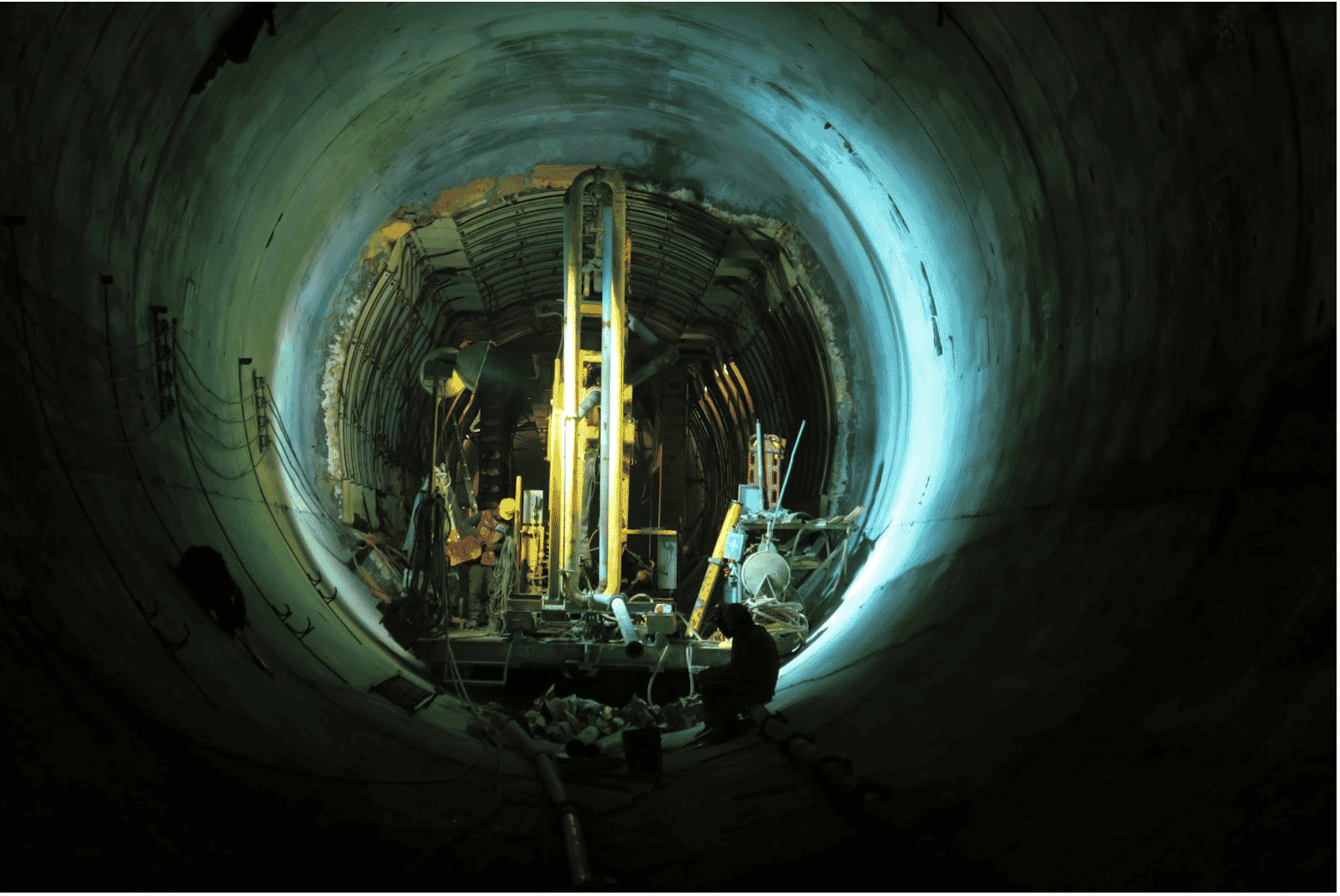 Construction workers in an underground tunnel work with long-lasting underground wiring solutions, including direct burial and corrosion-resistant building wires. The image highlights UV-resistant direct burial wire and heavy-duty outdoor wire solutions to ensure durability in harsh environments. These direct burial electrical cable solutions are essential for reliable and corrosion-resistant connectivity in challenging underground applications