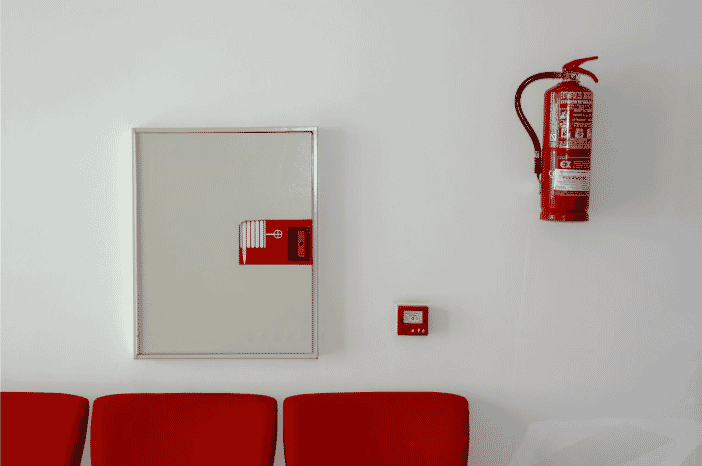 Fire safety equipment, including a mounted fire extinguisher and fire alarm cabinet, demonstrating the importance of armored fire alarm cables in ensuring system reliability and durability in high-risk environments