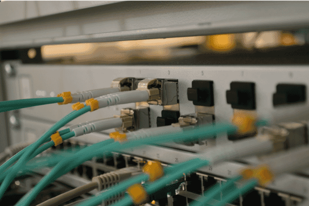 Fiber optic cables connected to a network switch, showcasing high-speed data transfer and reliable connectivity for smart building infrastructure and data centers