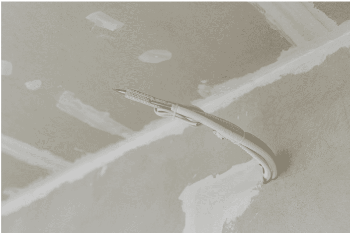 Low-smoke fire cable installation in a ceiling, showing the protective sheath and exposed copper wire used in buildings for fire-resistant electrical system