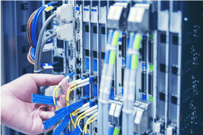 Technician connecting high-speed cables in a modern AV system, showcasing the role of advanced cabling solutions in seamless digital media transmission and efficient data transfer for professional environments