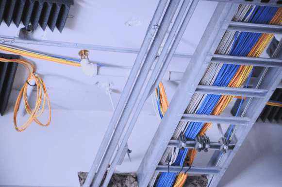 Organized cable management system in a commercial building showing neatly arranged Ethernet cables in cable trays, adhering to best practices to avoid common wiring mistakes in access control systems