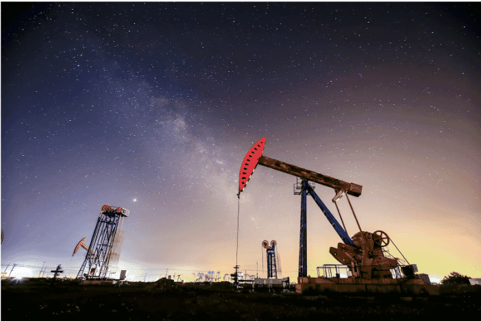 Oil pump jacks operating under a starry night sky, highlighting the critical role of corrosion-resistant petroleum wires in reducing maintenance costs and enhancing equipment reliability in harsh oil and gas industry environments