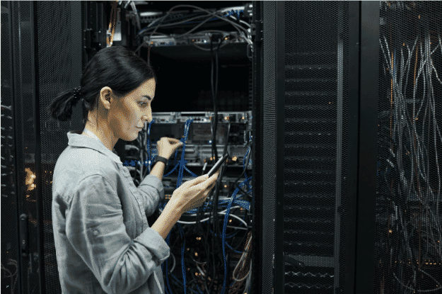 Technician managing Ethernet cables in a data center, illustrating the importance of choosing between Cat5e, Cat6, and Cat6a for optimal network performanceTechnician managing Ethernet cables in a data center, illustrating the importance of choosing between Cat5e, Cat6, and Cat6a for optimal network performance
