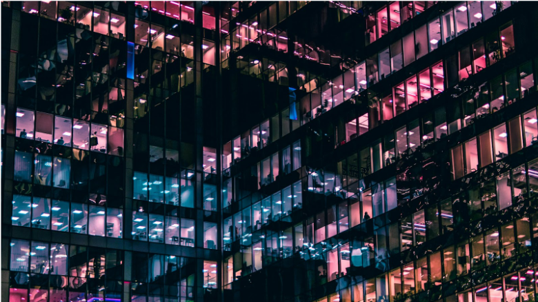 Modern office building with illuminated windows representing large commercial networks where LAN cable distance and Ethernet cable length limits affect structured cabling performance