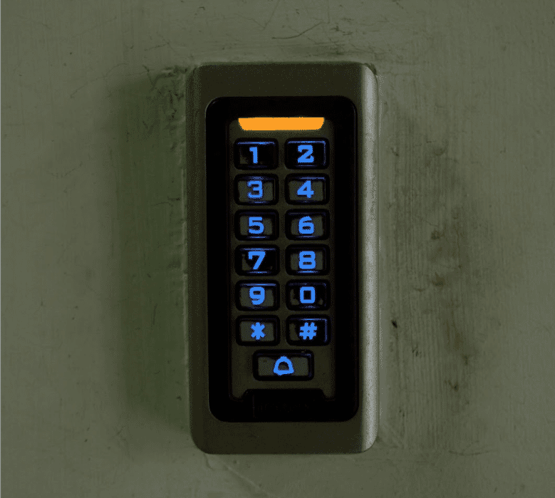 Secure access control keypad with illuminated blue numbers and symbols on a wall, showcasing modern security technology for controlled entry