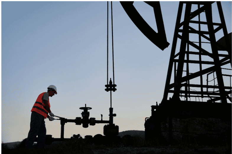 Oil field worker operating drilling equipment at an oil rig, where high-temperature petroleum-resistant cables ensure durability and reliability in extreme conditions