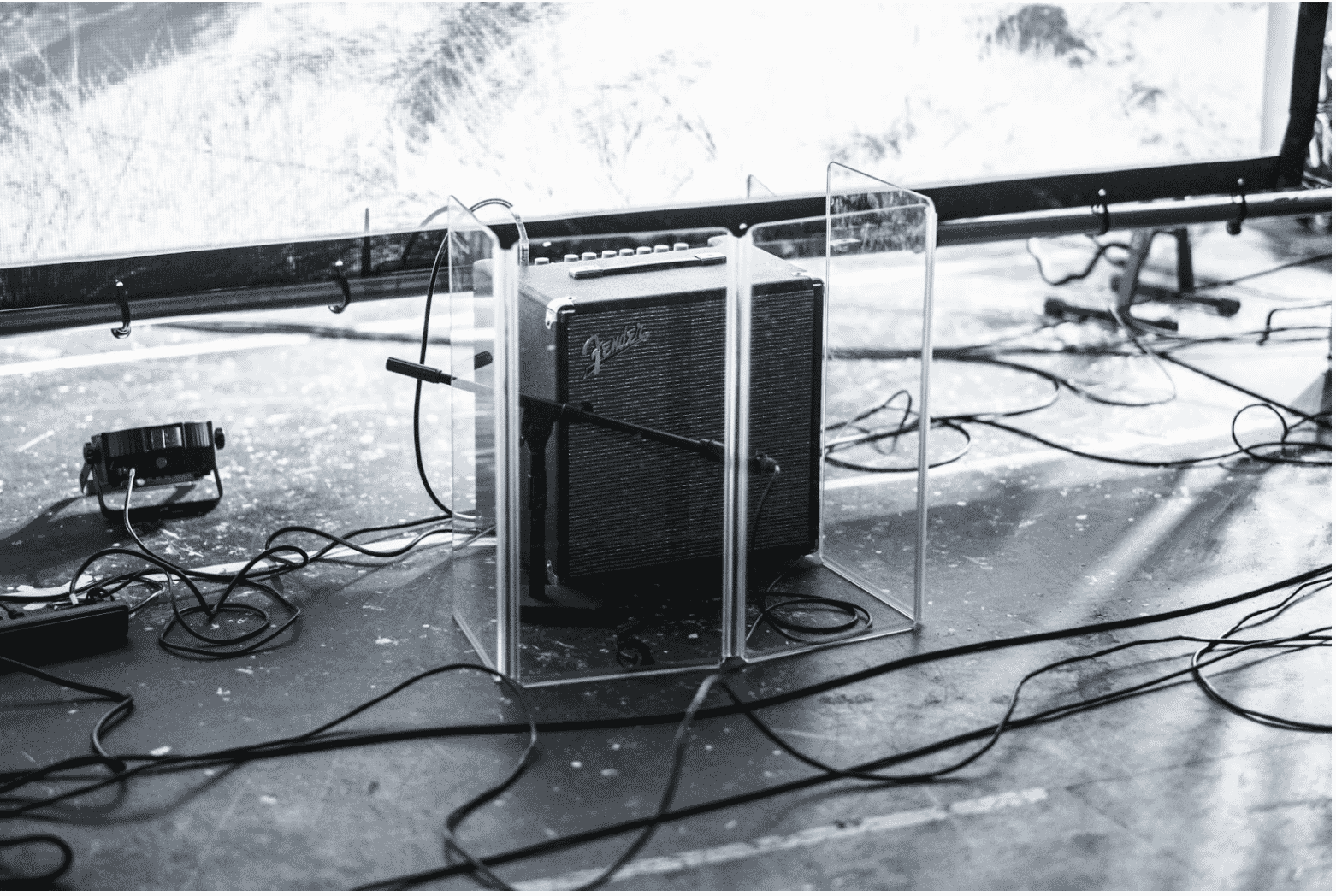 A stage setup featuring a Fender amplifier and multiple speaker cables highlights the importance of shielded speaker cables for clear audio performance