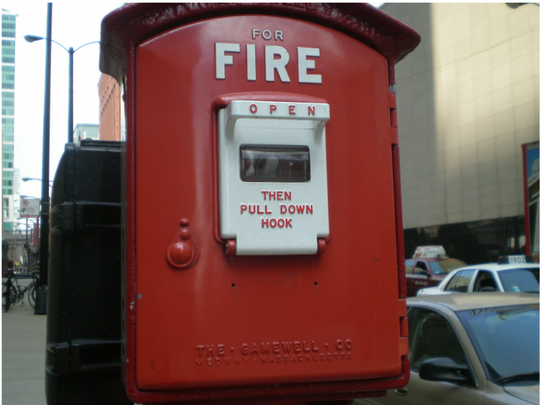 Red street fire alarm call box illustrating life safety emergency signaling infrastructure related to circuit integrity and 2-hour fire cable systems