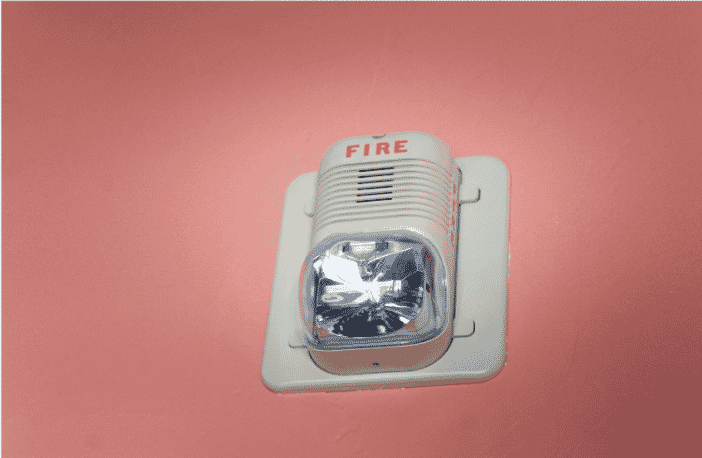Fire alarm on a wall, representing the importance of using plenum fire cables for enhanced safety in building systems