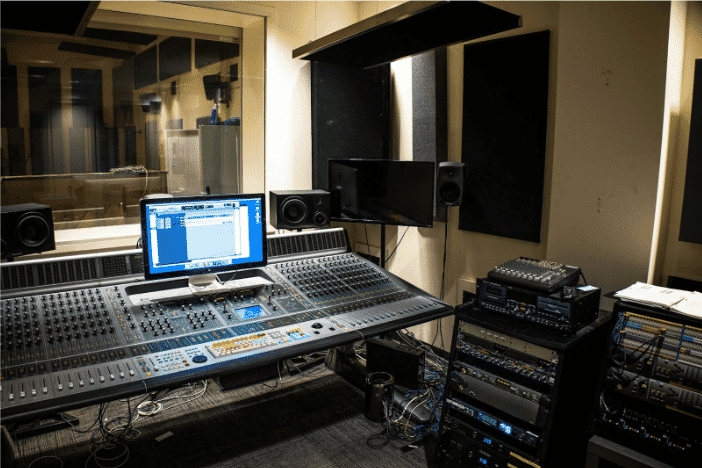 A professional audio recording studio featuring a large mixing console, highlighting the importance of reliable MIC line cables for high-quality sound production