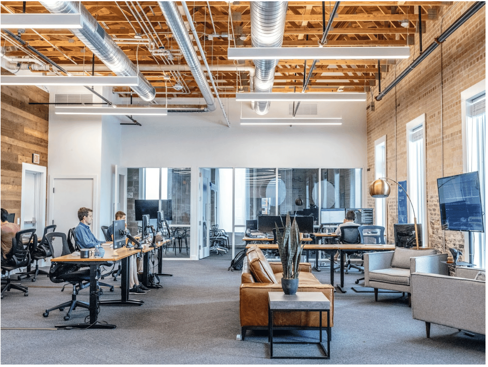 Open-plan office space with modern industrial design, highlighting efficient energy management cabling systems to power multiple workstations seamlessly