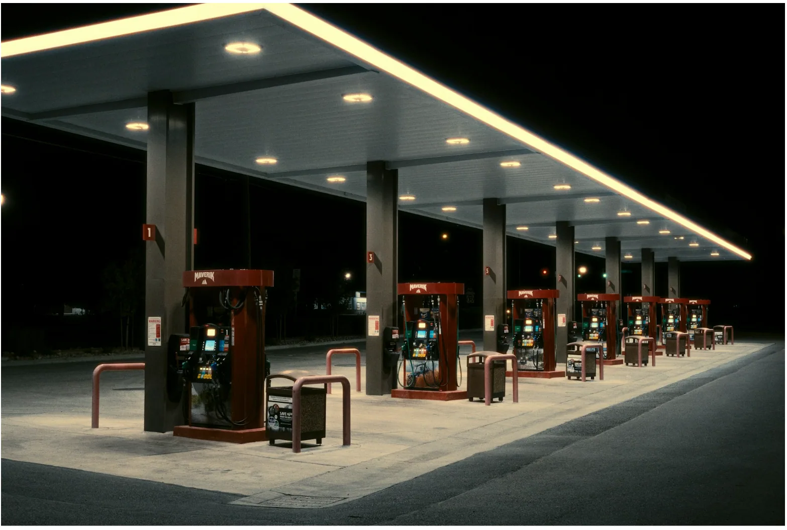 Commercial gas station fuel dispensers at night representing petroleum environments where shielded FEP control cables support dispenser communication and control systems