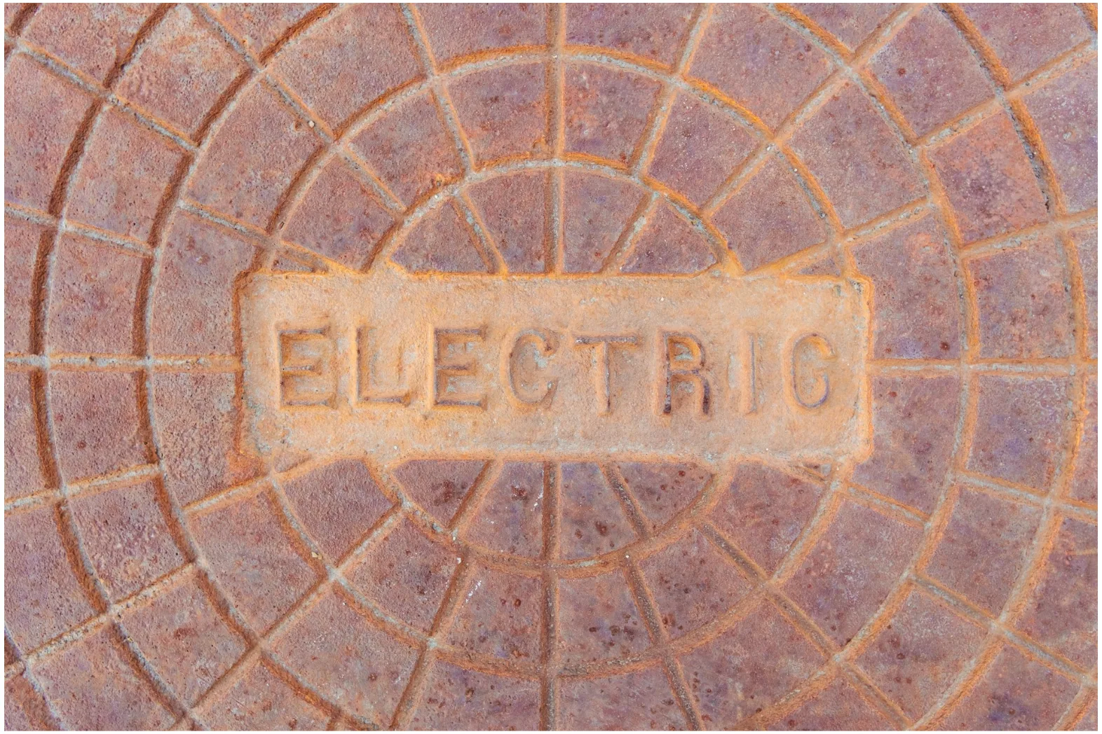 Underground electrical access cover representing CATV and outdoor cable infrastructure in commercial utility pathways