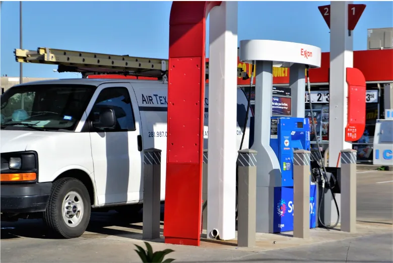 Service technician vehicle at a commercial gas station where petroleum-rated cable supports underground storage tank monitoring, CRIND systems, and secure EMV fuel transactions