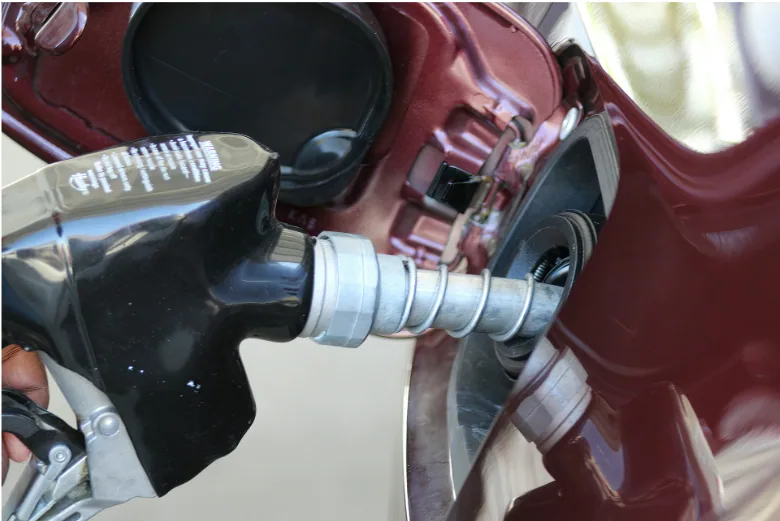 Fuel dispenser filling a vehicle at a gas station, representing the petroleum infrastructure supported by underground storage tank (UST) wire and cable systems