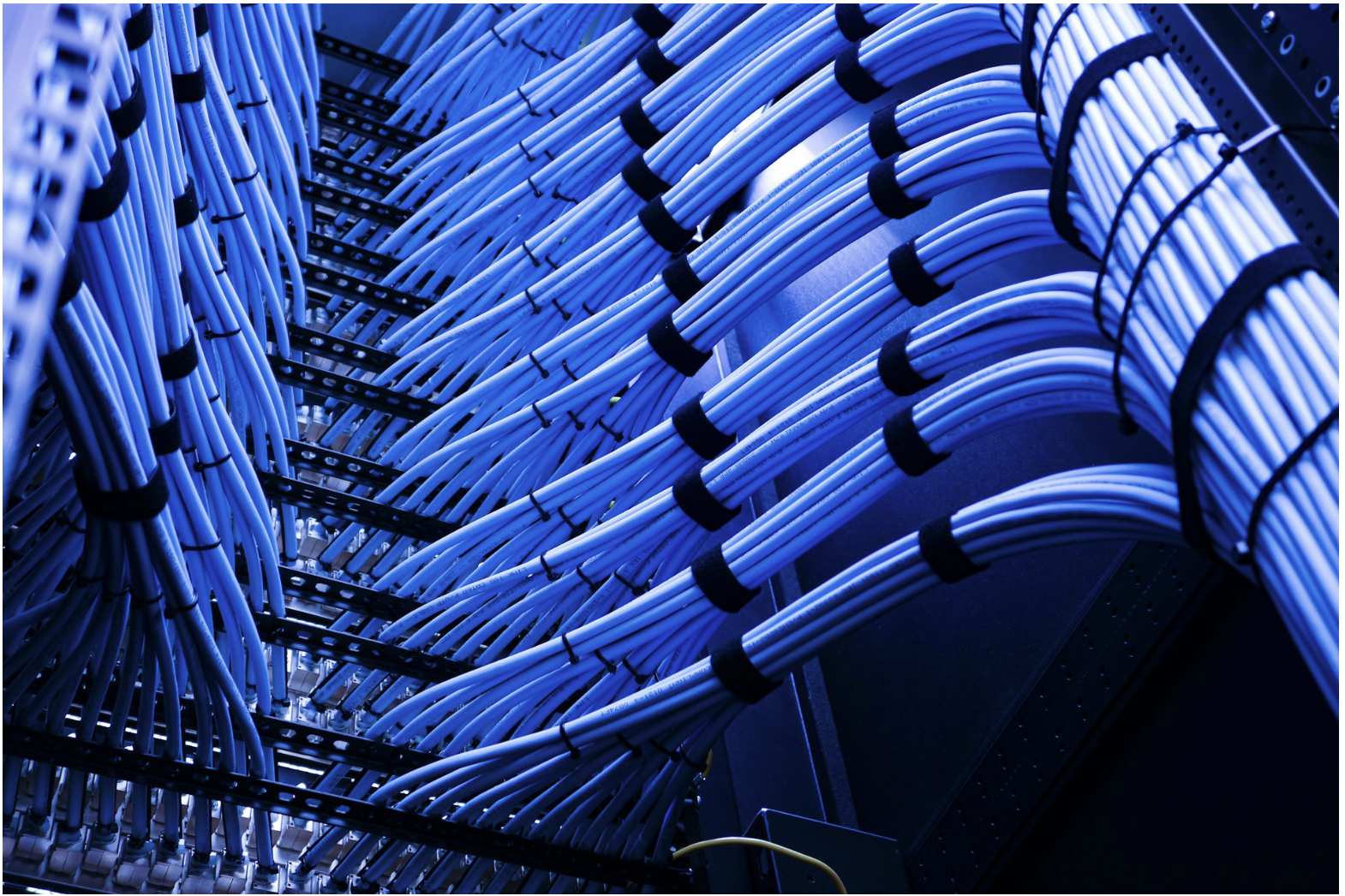 Organized Ethernet cable bundles in network rack, illustrating structured cabling systems where connectors and cable segments impact overall channel performance