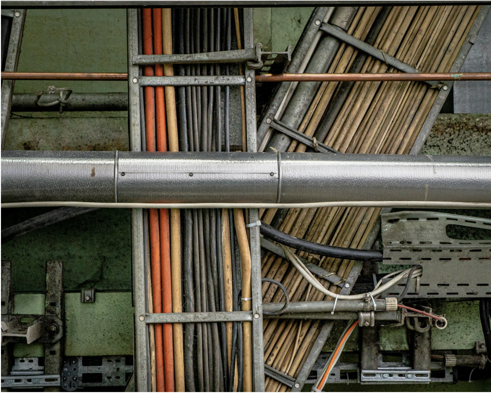 Cable tray with multiple colored Ethernet and power cables in a commercial installation showing organized cable routing and jacket color identification for outdoor Cat6 and structured cabling systems