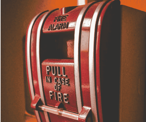 Red fire alarm system mounted on a wall, highlighting the importance of fire cables such as FPLP wire in emergency communication systems. This image emphasizes the use of plenum-rated fire alarm cables and high-performance FPLP fire wire for critical fire safety. Low-smoke plenum fire protection cables and low-smoke FPLP communication wires ensure safe, reliable operation during emergencies, while critical fire safety plenum wiring maintains system functionality in fire-prone environments