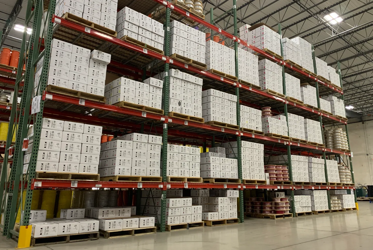 Organized warehouse racks of low‑voltage cable boxes and reels ready for shipment at Windy City Wire.