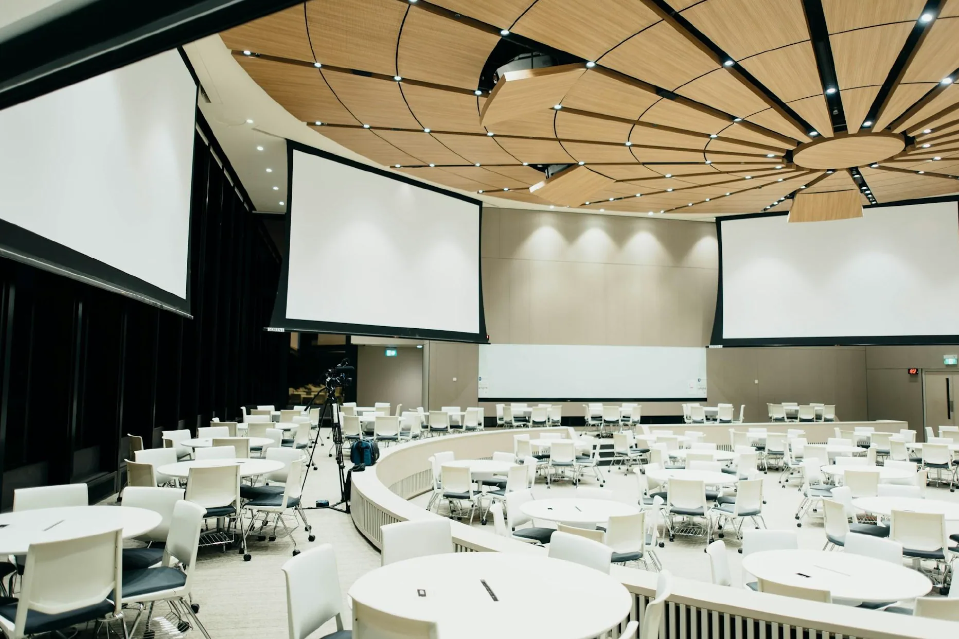 Modern commercial conference center featuring multiple large projection screens and AV infrastructure used for video distribution and network-connected presentations.